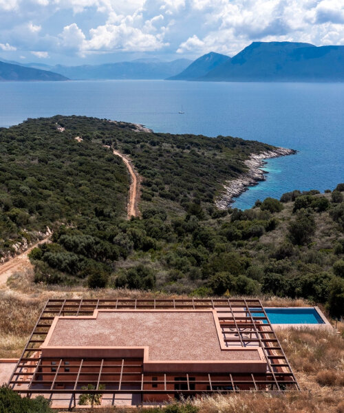 ateno's clay-coated house overlooks mountains and the sea on a greek island